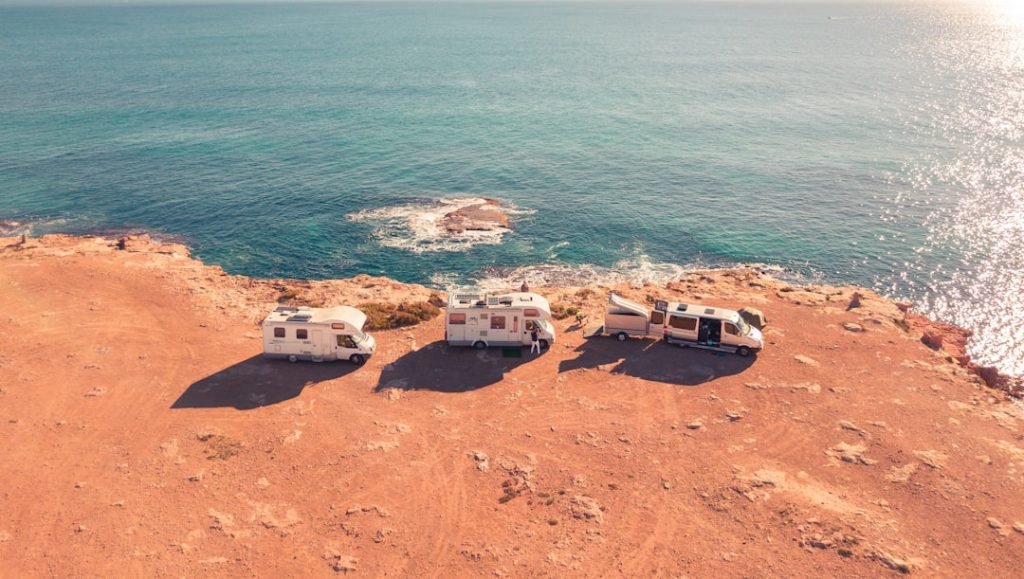 Ein einzigartiges Wohnmobil ist auf einer Klippe mit Blick auf das Meer geparkt