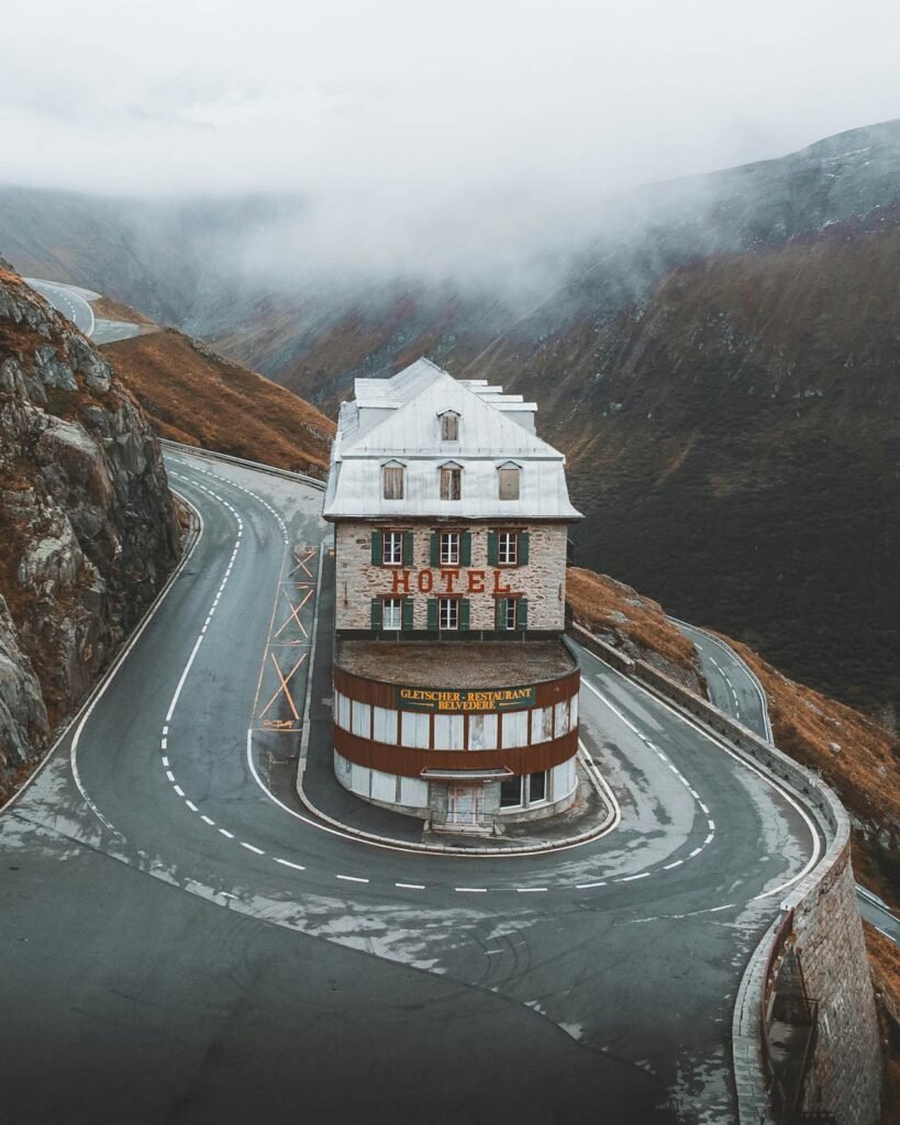 Malerisches Hotel direkt neben der berühmten Passstraße am Gotthardpass in der Schweiz, umgeben von alpiner Landschaft.Die 10 schönsten Wohnmobil Routen in der Schweiz