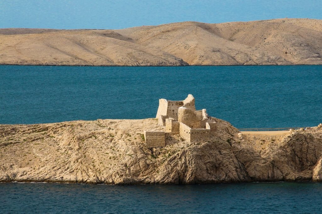 Mondähnliche Felslandschaft auf der Insel Pag mit den Überresten einer alten Steinhütte, die die raue Schönheit der Insel unterstreicht.