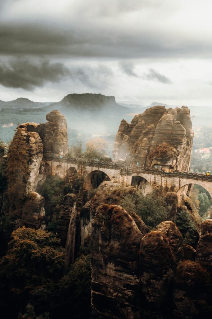Die spektakuläre Basteibrücke aus Sandstein im Elbsandsteingebirge der Sächsischen Schweiz, umgeben von grüner Natur.