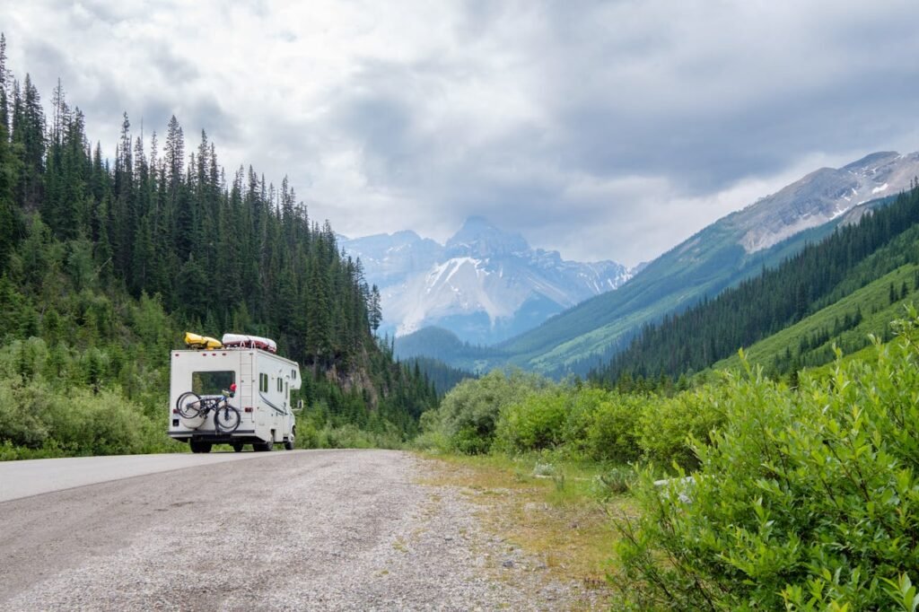 Ein Alkoven-Wohnmobil fährt durch eine Berglandschaft, die viel Stauraum für lange Expeditionen suggeriert.