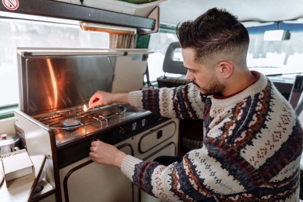 Mann zündet den Gasherd in seinem Camper-Van an. Das Bild symbolisiert die Autarkie-Challenge in Bezug auf Energie und Kochen beim Festival.